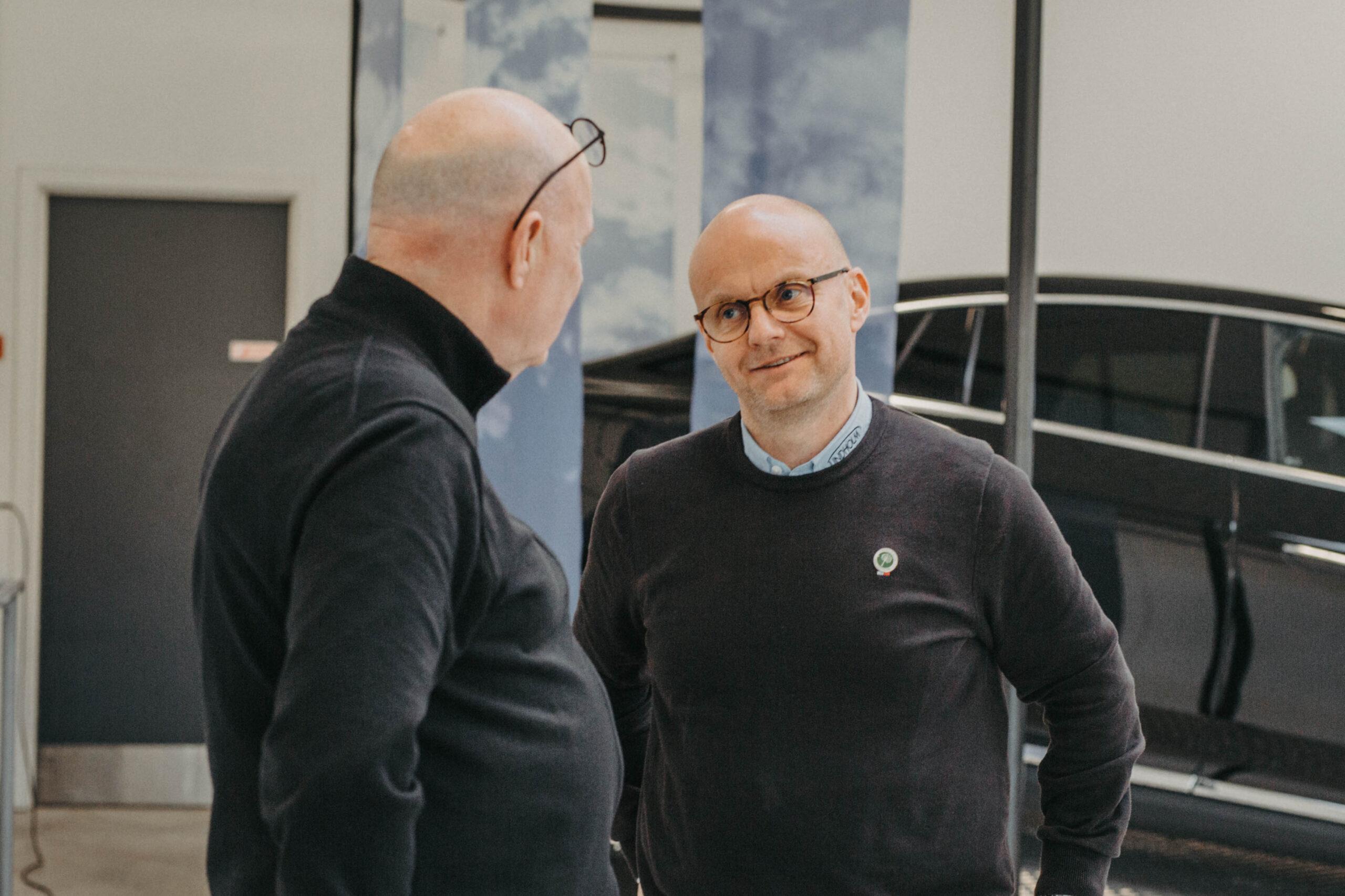Indehaver af Lindholm Biler Henrik Bollerslev i dialog med gæst i biludstilling hos Lindholm Biler