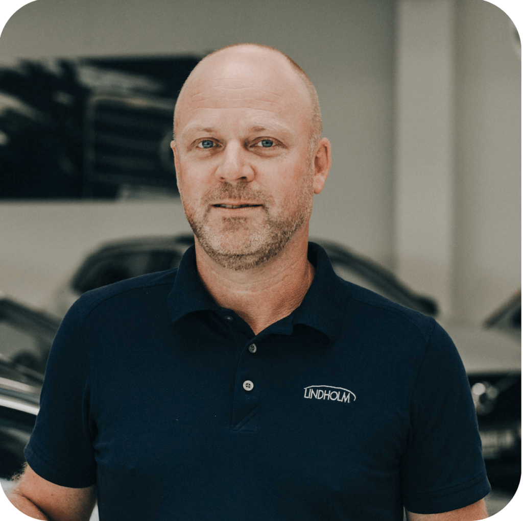 Profilbillede af Søren Rask salgsleder hos Lindholm Biler i biludstilling med biler i baggrunden